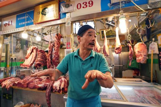 5月8日，在三源里市場內(nèi)的春蘭清真牛羊肉店，店主劉忠玉在介紹自己在三源里菜市場的開店經(jīng)歷。