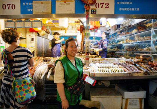 5月8日，在三源里市場，店主干丹君站在072號商鋪前。